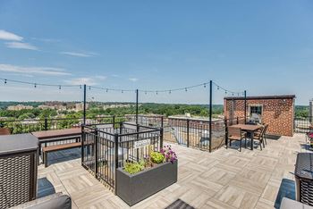 a roof deck with tables and chairs and a view of the city